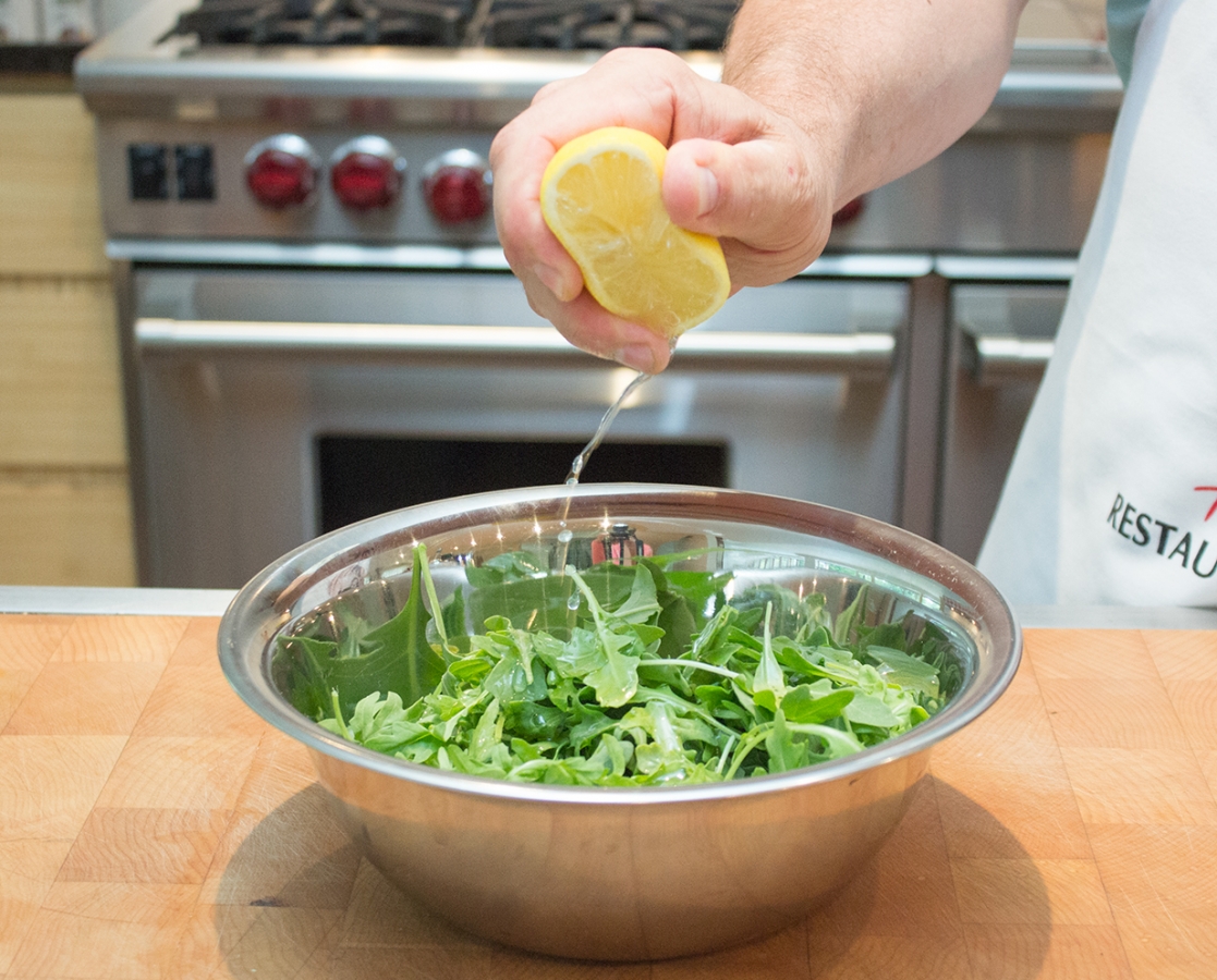 Slow roasted cherry tomato pizza with mozzarella topped with arugula salad