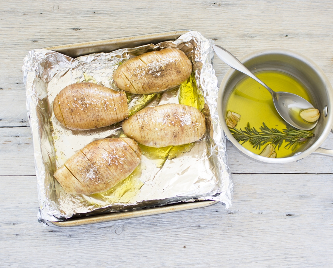 Pommes de terre à la suédoise (Hasselback) à l’infusion d’huile d’olive, d’ail et de romarin, rehaussées de parmesan