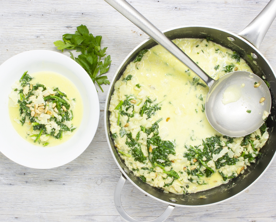 Soupe crémeuse au parmesan, aux épinards, au chou-fleur et aux noix de pins grillées