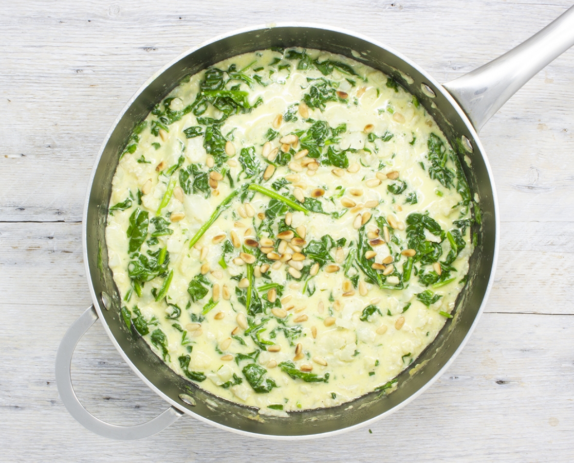 Soupe crémeuse au parmesan, aux épinards, au chou-fleur et aux noix de pins grillées