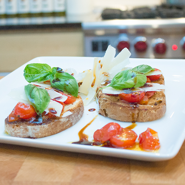 Bruschetta à la tomate cerise rôtie, écailles de parmesan et basilic frais