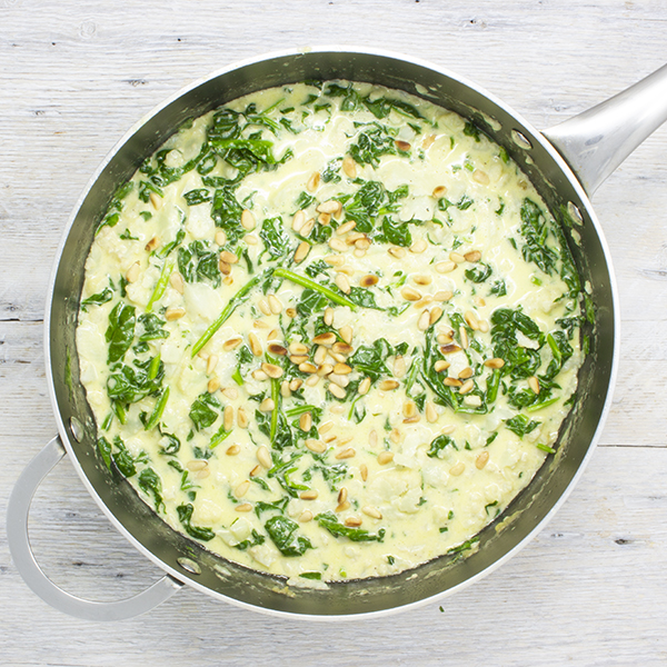 Soupe crémeuse au parmesan, aux épinards, au chou-fleur et aux noix de pins grillées