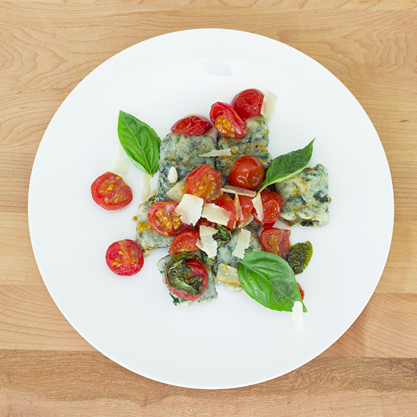 Gluten-free spinach ricotta gnocchi with garlic and fresh Basil confit cherry tomatoes