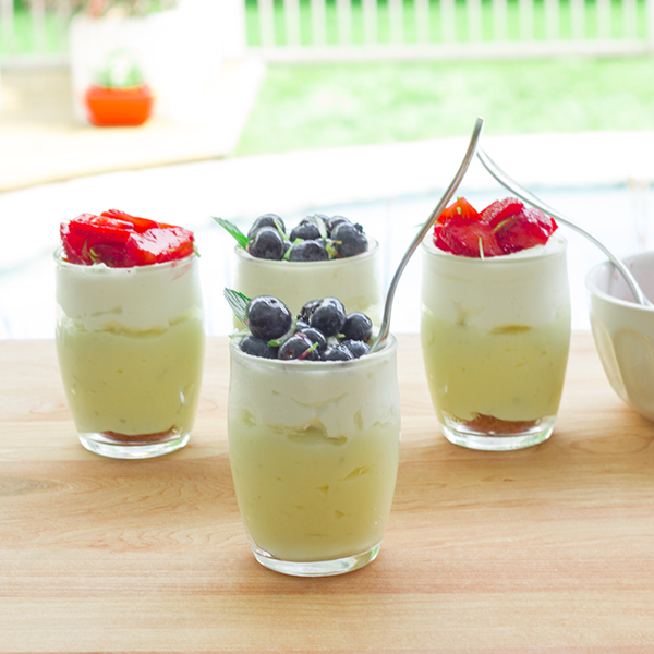 Lime-coconut custard verrine, on amaretto cookie topped with whipped cream and marinated fruits